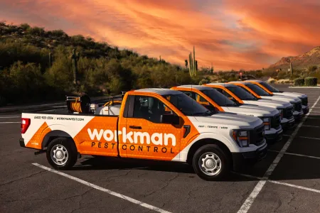 workman pest control trucks at sunset